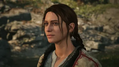 Anca standing beside the stream behind her hut